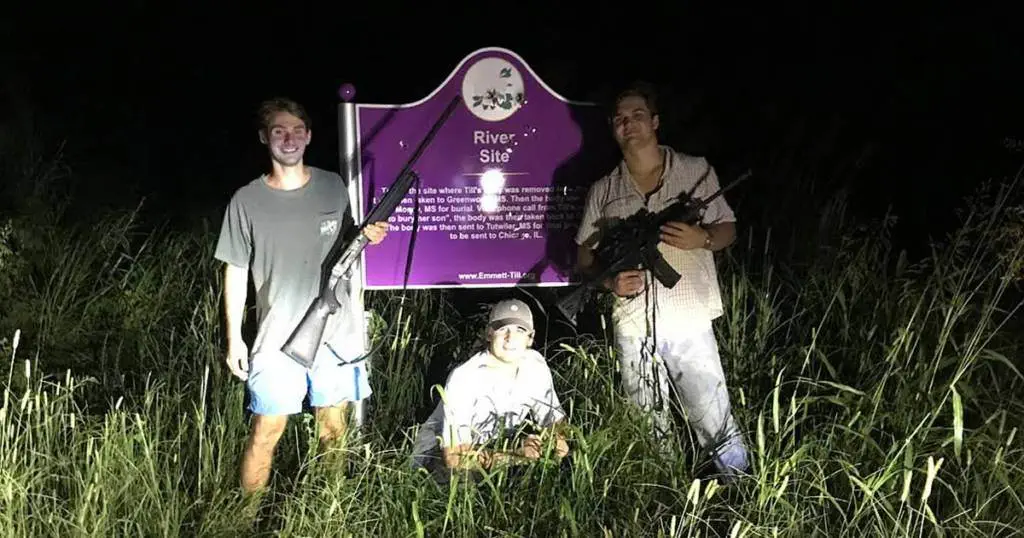 Racist frat boys posing in front of vandalized emmett till memorial sign
